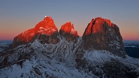 Aerial hyperlapse of sunrise over the snow-capped peaks of Val Gardena, Italy, with a full moon setting behind the mountains. Stunning pink and violet winter light captured in cinematic 4K. - Powered by Shutterstock - Get 15% off with code: PIKWIZARD15