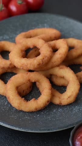 Onion rings or fried squid in breadcrumbs with sauce, takeaway food. Onion rings fried, fast food as a background for your design