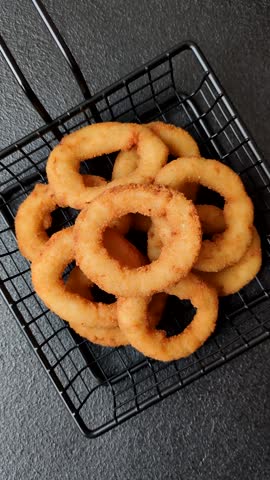 Onion rings or fried squid in breadcrumbs with sauce, takeaway food. Onion rings fried, fast food as a background for your design