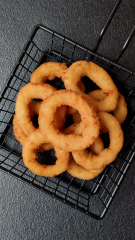 Onion rings or fried squid in breadcrumbs with sauce, takeaway food. Onion rings fried, fast food as a background for your design