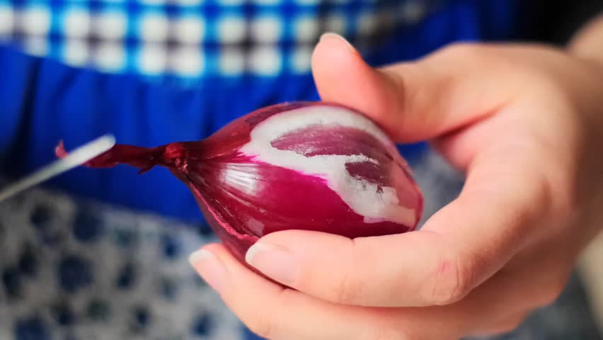 Slow Motion Macro Close-up of Hands Peeling the Skin from a Red Onion - Removing the Dry Outer Layer of a Fresh Purple Onion
