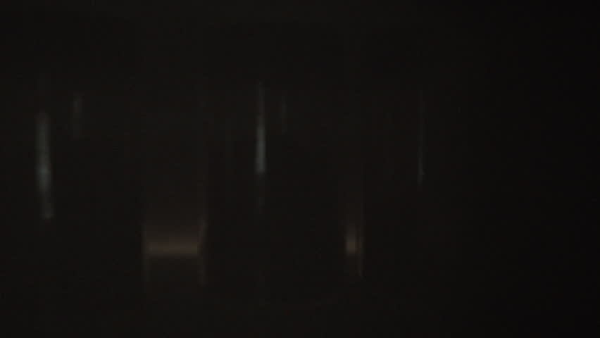 A man reaches into a cupboard to grab jars of seasoning. It is likely evening and he is preparing dinner in his kitchen, selecting the right flavors for his meal