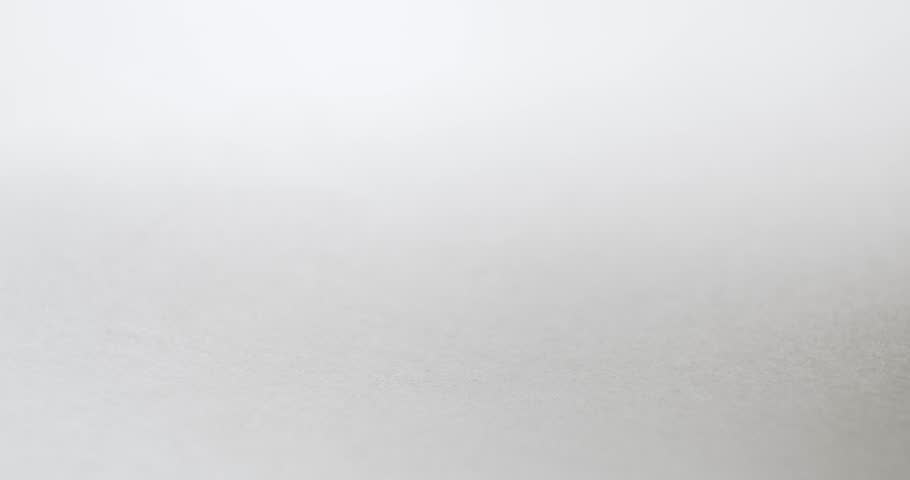 Single black marker drawing a straight line on blank white paper. Writing a smooth horizontal line with black ink absorbing into paper.