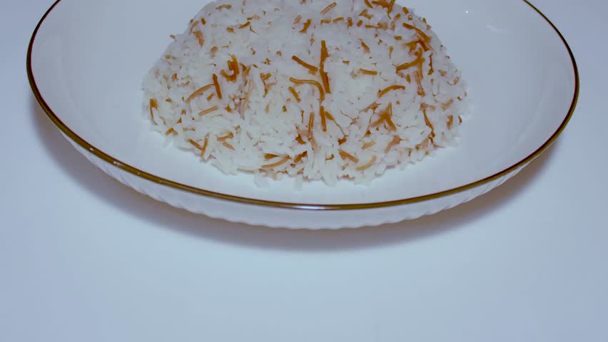 A plate of rice mixed with vermicelli noodles on a white background.