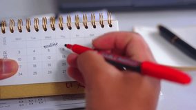 A person marks a calendar with a red marker, circling dates and marking deadlines and progress. Time management, planning, scheduling Important days, Deadlines
 - Powered by Shutterstock - Get 15% off with code: PIKWIZARD15