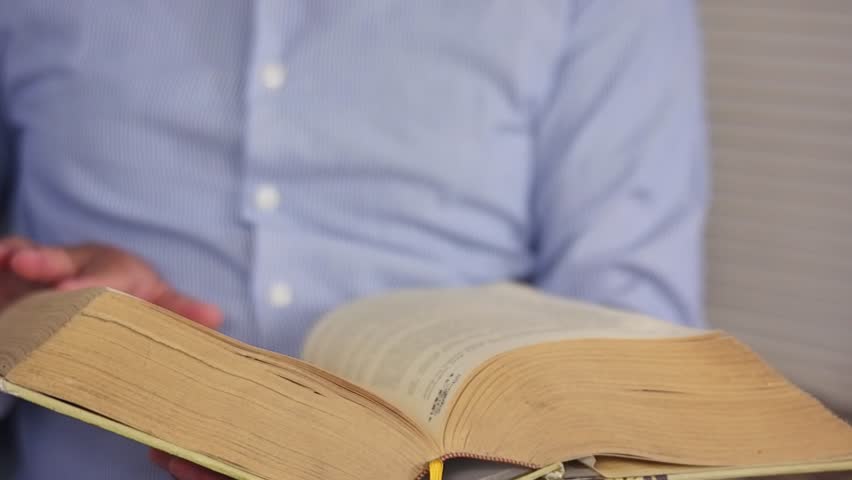 Opening a book to search for specific information, educational learning in literary textbooks in academic fields at the reading table in the school library classroom. Cognitive knowledge and learning.