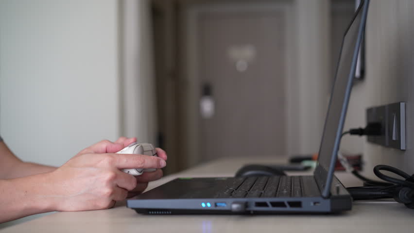 Closeup people hand or gamer holding joystick or wireless gaming controller to enjoy playing game on computer notebook or laptop console by joy stick in living room for entertrainment relax on holiday