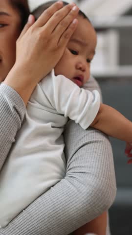 Loving mother gently caressing newborn