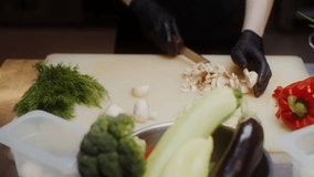 A woman chef wearing black disposable gloves slices mushrooms, showcasing professional cooking, food preparation, hygiene, and culinary techniques in action. - Powered by Shutterstock - Get 15% off with code: PIKWIZARD15