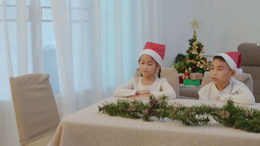 Christmas family home, happy kid, parent celebrating holiday, presents under tree, person brings pizza for young children wearing Santa hats.