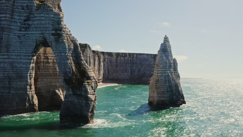 Sheer cliffs with natural arches are washed by the waters of the English Channel, showcasing dramatic coastal rock formations and serene seascapes.