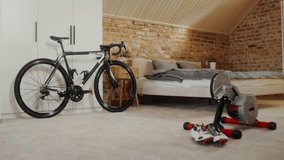 A bike is set up on a stationary trainer in a bedroom, ready for indoor cycling and home workout exercise. - Powered by Shutterstock - Get 15% off with code: PIKWIZARD15