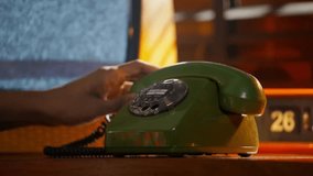 Close-up of a man dialing a number on a wired phone, focusing on his hands and the phone in a realistic office or home setting. - Powered by Shutterstock - Get 15% off with code: PIKWIZARD15
