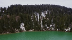 A snow-covered hill densely overgrown with fir trees on riverbanks, capturing a serene winter landscape, forest textures, and natural alpine beauty. - Powered by Shutterstock - Get 15% off with code: PIKWIZARD15