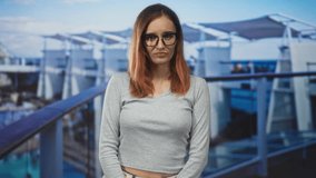 Woman redhead wearing glasses points index finger and furrows brow in studio against cruise ship backdrop; skepticism doubt scrutiny. - Powered by Shutterstock - Get 15% off with code: PIKWIZARD15