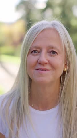 Happy senior woman with gray hair smiling outdoors