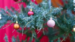 Festive Celebration with Beautifully Decorated Christmas Tree Adorned in Colorful Ornaments of Pink, Gold, and Red, Creating Joyful Atmosphere Against Vibrant Red Background - Powered by Shutterstock - Get 15% off with code: PIKWIZARD15