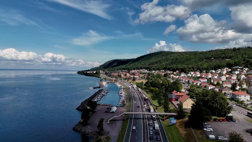 Aerial View of Coastal Town and Seaside Highway Along Blue Ocean