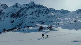 Two backpacker tourists hiking on snowy and epic mountain scenery during winter day, aerial shot of father and son walking through deep snow.  - Powered by Shutterstock - Get 15% off with code: PIKWIZARD15