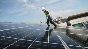 Technician installing solar panels on factory roof for green energy. A skilled technician in safety gear is working on a solar panel installation on rooftop. clean energy renewable power technology. - Powered by Shutterstock - Get 15% off with code: PIKWIZARD15