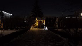 Magical winter night scene with a wooden treehouse decorated with warm festive lights, glowing Christmas stars, illuminated reindeer sculpture and snowman figure surrounded by fresh snow in a garden - Powered by Shutterstock - Get 15% off with code: PIKWIZARD15