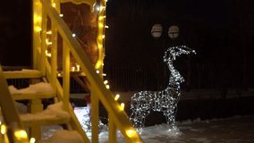 Illuminated wireframe reindeer sculpture with warm yellow holiday lights on a snowy wooden playhouse staircase during a festive winter night in a decorated outdoor yard scene - Powered by Shutterstock - Get 15% off with code: PIKWIZARD15
