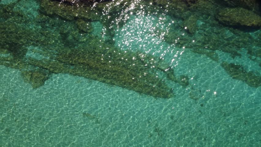 Crystal Clear Water Reveals Hidden Rocks Beneath the Surface at a Serene Coastal Area