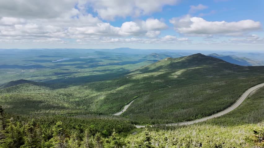 A breathtaking panoramic view from the summit of Whiteface Mountain in Wilmington, New York, showcasing vast mountain ranges, crisp air, and stunning natural scenery.