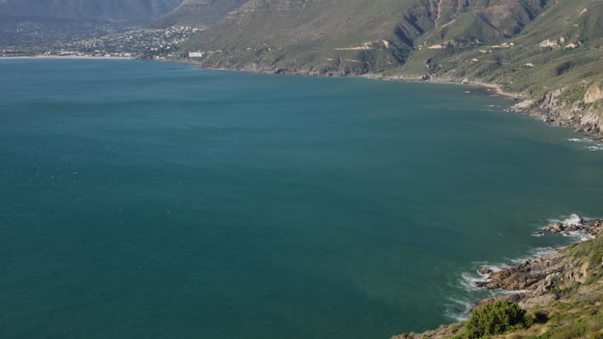 Panoramic view of Hout Bay and coastal mountains from Chapman’s Peak view point, Cape Town, Cape Peninsula, Western Cape, South Africa. Iconic tourist destination. 30fps footage captured in 4k 60p.