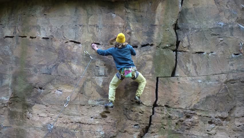 Climbing in Heidelberg-Schlierbach. Climbing in the Odenwald Climbers on a rock face in the forest. Climbers with yellow hats and blue jacked
