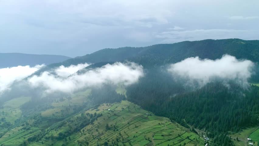 Green mountain valley with white clouds above, green mountain valley beneath white clouds creates majestic serene landscape. breathtaking nature ideal for exploration