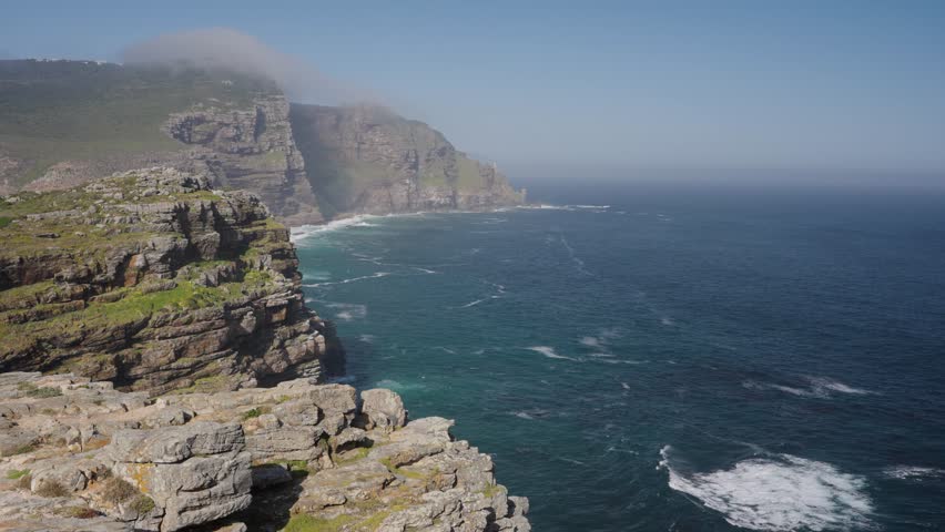 View of Cape Point from the Cape of Good Hope with the upper lighthouse shrouded in mist, which is why the lower one was built. Table Mountain National Park. Cape Town. Western Cape. South Africa.