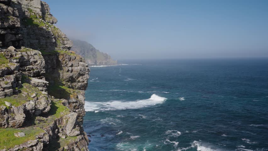 View of Cape Point from the Cape of Good Hope with the upper lighthouse shrouded in mist, which is why the lower one was built. Table Mountain National Park. Cape Town. Western Cape. South Africa.