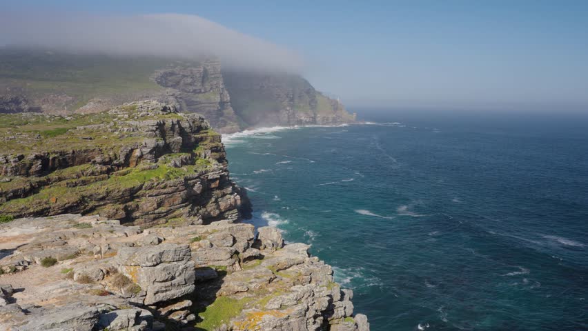View of Cape Point from the Cape of Good Hope with the upper lighthouse shrouded in mist, which is why the lower one was built. Table Mountain National Park. Cape Town. Western Cape. South Africa.