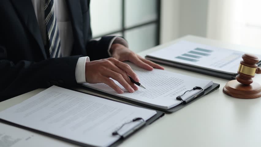 Legal counsel reading contract paperwork to finalize a legal agreement. Concepts for legal counsel, judicial authority, and the finality of a decision or agreement. 