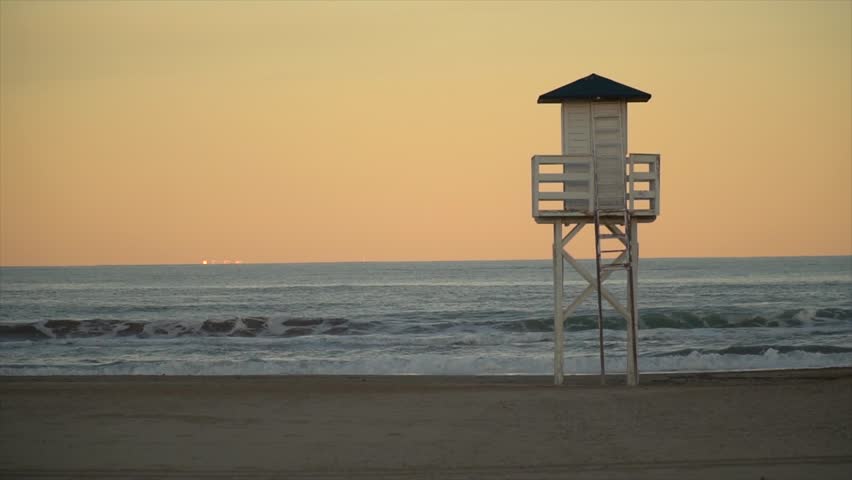 Slow motion. Lifeguard cabin on a peaceful sunset.