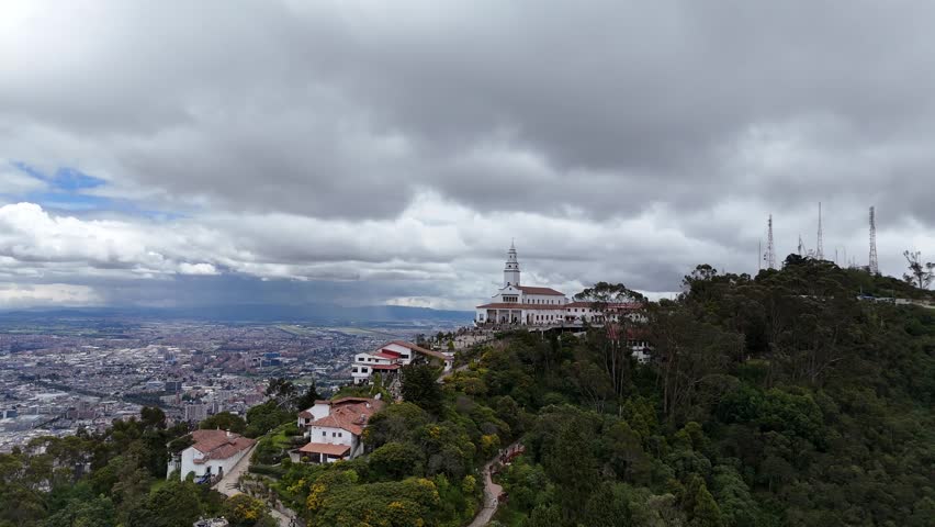 Aerial circle of the iconic Monserrate Church Sanctuary overlooking the sprawling capital city of Bogotá, Colombia. A major religious pilgrimage site