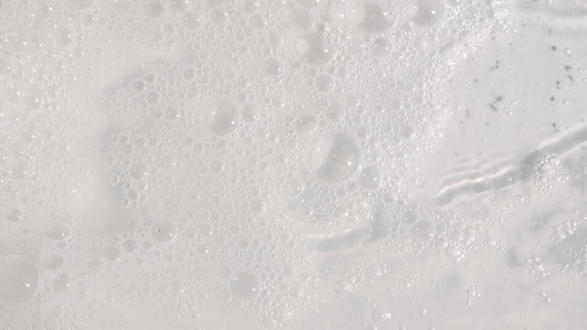 Texture of white soap foam with bubbles abstract background. Soap sud macro structure. Bathtup Soap Foam. Natural White Shampoo Bubbles Motion.