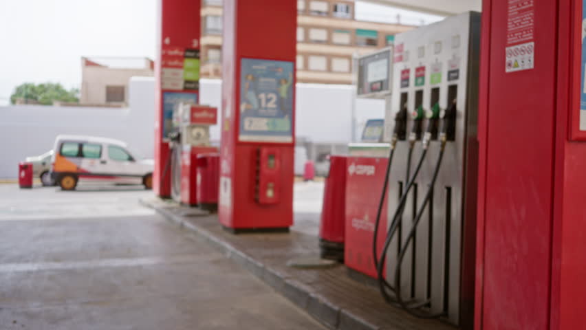 Gas station forecourt with red pumps, defocused bokeh background station; background backplate copyspace template.