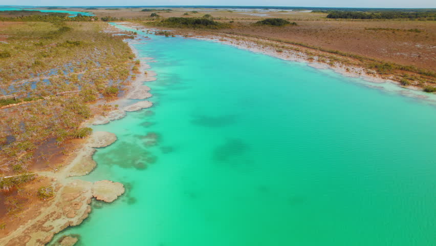 Aerial view of turquoise Bacalar Lagoon shoreline with stromatolite formations