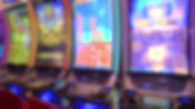 Row of vertical slot machines glowing with vibrant blue, green, pink and purple digital graphics in a modern casino. - Powered by Shutterstock - Get 15% off with code: PIKWIZARD15