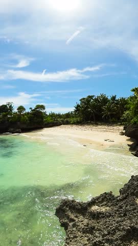 Turquoise sea water and waves in sandy beach. Carabao Island in Romblon, Philippines. Vertical view.