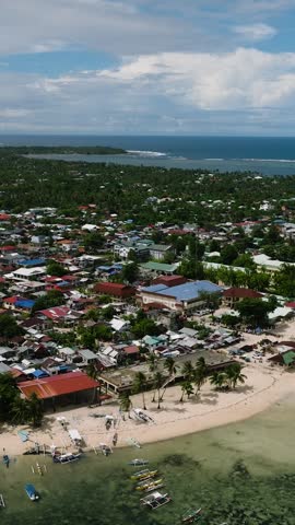 Coastal settlement with fishing boats on the water and houses close to the sea. General Luna, Siargao, Philippines.