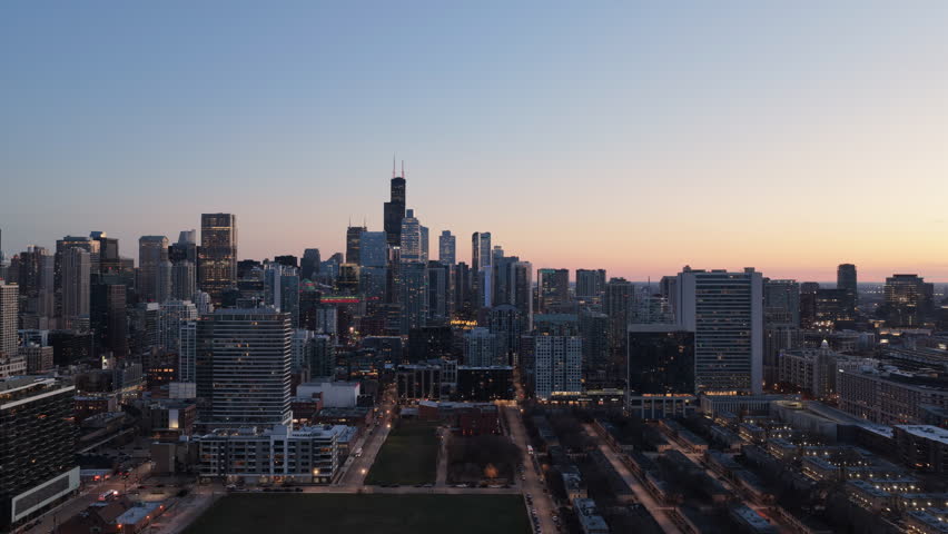 Chicago downtown skyscrapers at sunset. Tall buildings with city skyline, warm sunset sky