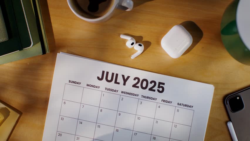 A woman marks the month on a calendar with a red marker, capturing a close-up of planning, organization, and time management in a modern, everyday setting.