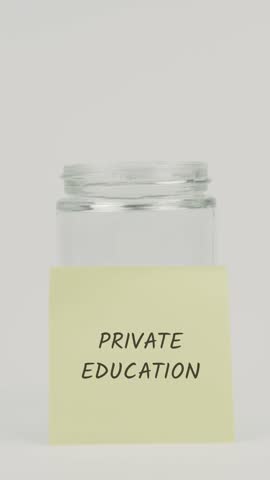 A hand deposits a coin into a glass jar featuring a yellow sticky note with Private Education, symbolizing saving for school fees, tuition costs, high-quality learning, and children