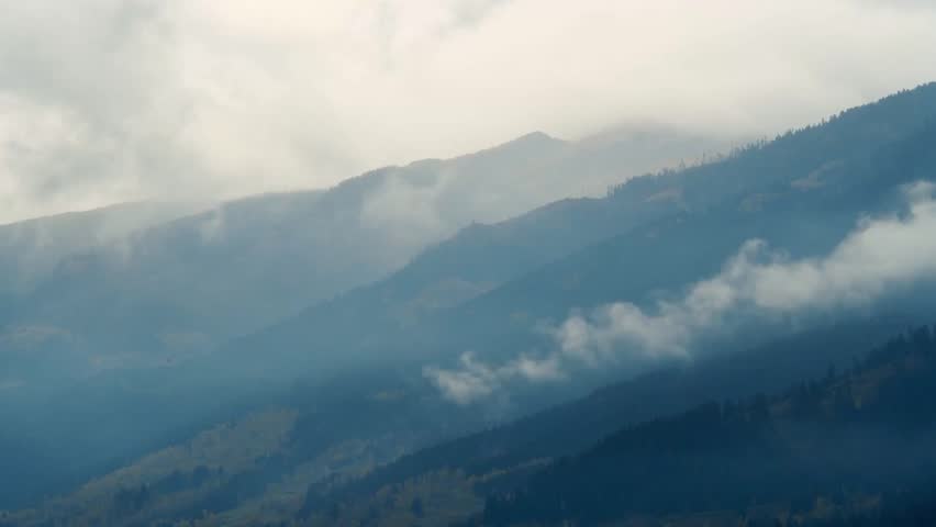 Foggy mountain landscape with mist covering rugged peaks, creating a mysterious and atmospheric high-altitude scene with dramatic natural textures and serene wilderness.
