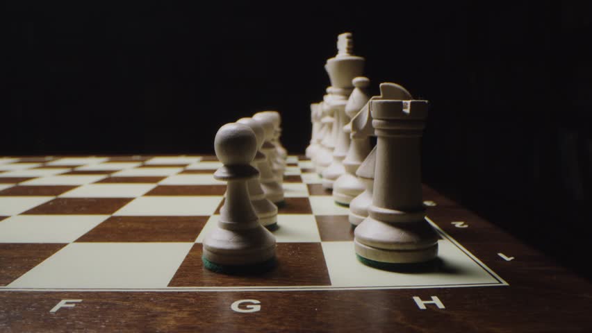 White chess pieces are arranged in even rows on a game board, ready for play, showcasing strategy, board game setup, and intellectual recreation in a close-up view.
