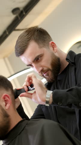 Professional barber giving haircut with clipper. Clip