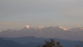 Stunning Alpenglow on Himalayan snow peaks during sunrise, golden pink light on mountains, telephoto view from Almora Uttarakhand 4K - Powered by Shutterstock - Get 15% off with code: PIKWIZARD15